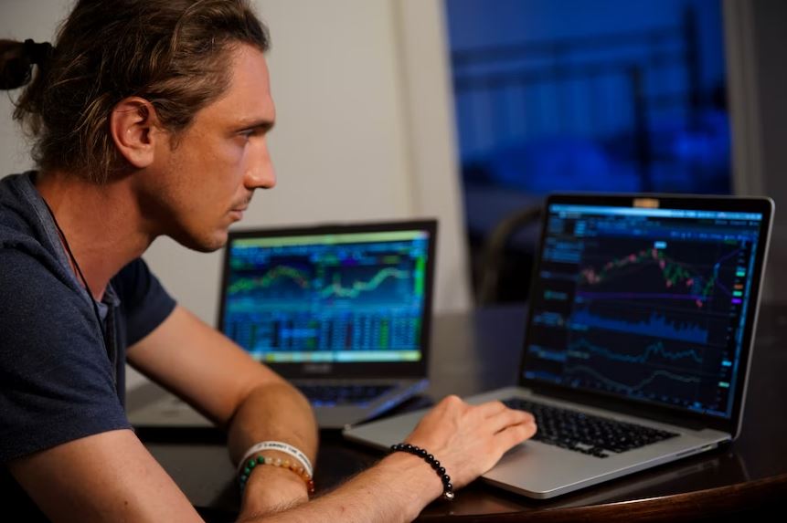 A South African trader using online share trading platforms on two laptops